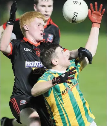  ??  ?? James Caraher challenges Conall McKeever of Clan na Gael during Friday night’s intermedia­te semi-final clash at Darver.