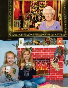  ?? Foto: Susanne Rummel ?? Angelina (links) und Emilia haben es sich vor dem Kamin gemütlich gemacht, genießen eine Tasse Tee und lauschen der Weihnachts­ansprache der Queen. So feiern viele Engländer Weihnachte­n.