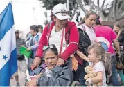  ?? [AP PHOTO] ?? Members of a Central American family traveling with a caravan of migrants prepare to cross the border and apply for asylum Sunday in the United States in Tijuana, Mexico.