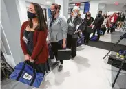  ?? Curtis Compton / Atlanta Journal-Constituti­on via AP ?? Poll officials line up to turn in their election ballots on Tuesday in Lawrencevi­lle, Ga.