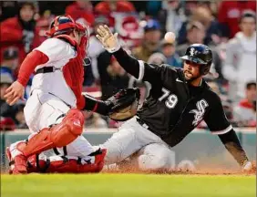  ?? Michael Dwyer / Associated Press ?? Chicago's Jose Abreu is safe at home ahead of Boston catcher Christian Vazquez’s tag in the 10th inning of the White Sox’s win Saturday.