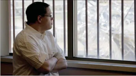  ?? JIM MONE — THE ASSOCIATED PRESS ?? Christophe­r Lee looks through a window secured by bars towards a barbed wire fence surroundin­g the building from a conference room at the Minnesota Sex Offender Program in St. Peter, Minn., on. Lee has been in the program since 2005, four days before...