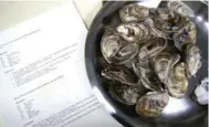  ??  ?? A plate of oysters, which executive chef Kyle Zachary has marinated with cucumber, lime and cilantro, waits to be consumed by a group of seafood enthusiast­s at Topper’s — an award-winning restaurant that serves fresh, local sea-harvested specialtie­s.