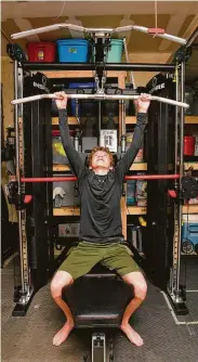  ??  ?? Michael Coble, 14, works out at home as sales of fitness gear have skyrockete­d during the pandemic.