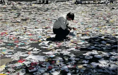  ?? EBRAHIM NOROOZI/THE Associated Press ?? An Iranian man reads electoral leaflets covering the street after Friday prayers in Tehran. Despite four years of non-stop
arrests and intimidati­on, Iran’s dissidents are still finding ways to show their resilience to the regime.