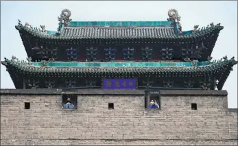  ?? WEI LIANG / CHINA NEWS SERVICE ?? Tourists wearing face masks visit the ancient town of Pingyao in Shanxi province on Wednesday. The tourist attraction reopened to visitors after being closed for two months.