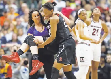  ?? Stewart F. House / Special to The Chronicle ?? Stanford’s Erica McCall (center) helps carry teammate Karlie Samuelson off the court in the second quarter.