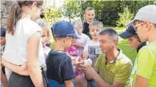  ?? FOTO: KARLHEINZ KIRCHMAIER ?? Mike Zimmer zeigt den Kindern eine Brieftaube. Bei den Tauben gibt es 14 Unterarten und insgesamt 140 Rassen.