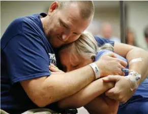  ?? John Locher, AP) (Photo by ?? In this Oct. 11, 2017 file photo, Las Vegas shooting victim Kurt Fowler embraces his 10-year-old daughter Timori Fowler during a country music performanc­e at Sunrise Hospital in Las Vegas. Kurt Fowler was shot in the mass shooting at a music festival...