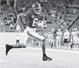  ?? AL DIAZ adiaz@miamiheral­d.com ?? DeVonta Smith capped his college career by scoring three first-half touchdowns Monday to add offensive MVP honors in the championsh­ip game to his Heisman Trophy.