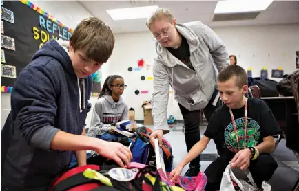  ?? Staff photos by Evan Lewis ?? Gifted and talented students at Liberty-Eylau Middle School, above, stuff backpacks for the homeless as part of the Gifts from Grace project. Pictured from left are Daymon Finigan, Olivia Forte, Halley Tubb and Wade Bourne. Created by Grace Cantu and...