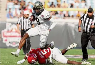  ?? Sam Greenwood / Getty Images ?? A.T. Perry of Wake Forest runs for yardage against Rutgers during the Gator Bowl in Jacksonvil­le, Fla., on Friday. Perry had 10 receptions for 127 yards and a TD.