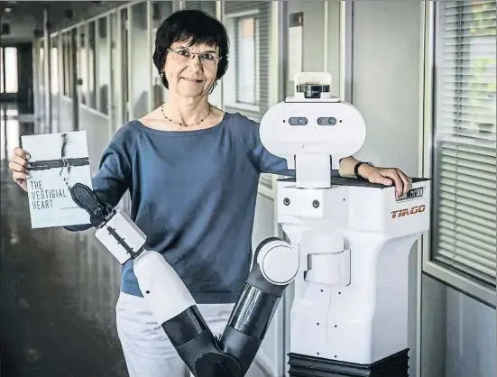  ?? LLIBERT TEIXIDÓ ?? La investigad­ora Carme Torras, acompañada del robot Tiago, muestra un ejemplar de su novela, traducida al inglés como The vestigial heart