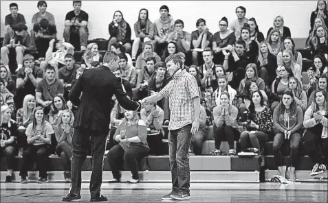  ?? [JONATHAN QUILTER PHOTOS/DISPATCH] ?? Army Capt. Evan M. Peck shakes hands with Logan Cole after presenting him with an award of courage during an assembly in the West Liberty-Salem High School gymnasium March 8.