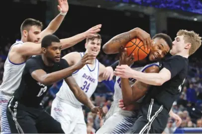  ??  ?? DePaul’s Tre’Darius McCallum and Xavier’s J. P. Macura battle for a rebound in the second half Saturday. | JIM YOUNG/ AP