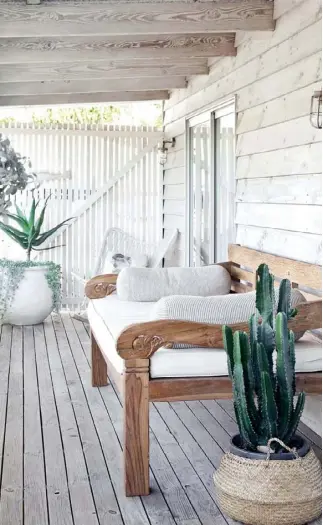  ??  ?? VERANDAH
This breezy space is the perfect retreat on a steamy Sunshine Coast afternoon (above), and a gorgeous daybed from Eclectic Style offers ample room to stretch out after a long lunch. “Summer in here is great,” says Nilla. “We spend most of our time on the verandah with a gin and tonic and a grazing platter.” A white pot from Acres Garden Centre overflows with silver mist next to a rocker from CLO Studios.