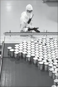  ?? GUO LEI / XINHUA ?? A supervisor oversees the canning process in a China Mengniu Dairy factory in Waikato, New Zealand.