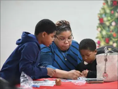  ?? ERIC BONZAR — THE MORNING JOURNAL ?? Detania Jackson spends time coloring with her sons Javon, 8, and Kylen, 5, during Cookies &amp; Cocoa with Santa at Knights of St. John, 1620 Kansas Ave., Dec. 22.