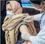  ?? DAR YASIN/AP ?? A hospital staff member receives a COVID-19 vaccine Saturday at a government hospital in Srinagar in Indiancont­rolled Kashmir.