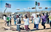  ??  ?? Tohono O’odham people dance and sing to protest against Donald Trump’s plan to build a wall through their reservatio­n, above. The original border markers, top