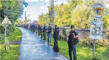  ?? FOTOS: FLEMMING ?? Von der Grenze zu Österreich bis zum Giebelbach bilden Corona-Gegner in Lindau eine Menschenke­tte.