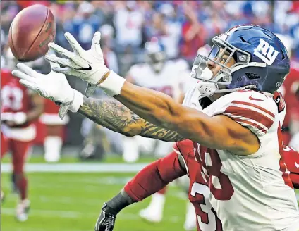  ?? AP ?? RIB TOAST: Evan Engram, reaching for the ball, had just one catch before exiting in the first quarter of the Giants’ 23-0 loss to the Cardinals with a rib injury, which puts the rookie in jeopardy of missing the teams’ season finale.