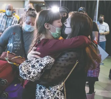  ?? GREG LOCKE / THE CANADIAN PRESS ?? Nine-year-old Zoriana greets her big sister, Sofiia Shapoval, with a hug after arriving at St. John's
Internatio­nal Airport from Ukraine with their mother, Natalia, earlier this month.