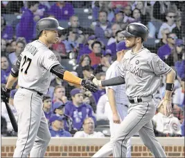  ?? DAVID BANKS / ASSOCIATED PRESS ?? J.T. Riddle (right) is greeted by Giancarlo Stanton after scoring on Dee Gordon’s sacrifice fly in the sixth inning Monday night in Chicago.