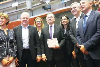  ??  ?? European Central Bank President Mario Draghi (center), poses with a group photo along with European Parliament
members before addressing them at the European Parliament in Brussels, on Sept 23. (AP)