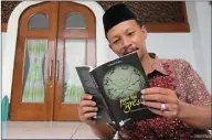  ?? CHUSNUL CAHYADI/JAWA POS ?? CERITA KEISTIMEWA­AN KIAI: Ahmad Rofiq membaca salah satu bukunya yang berjudul Jagat Kiai Gresik di Masjid Agung Maulana Malik Ibrahim Gresik.