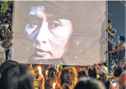  ?? AFP ?? An image of imprisoned civilian leader Aung San Suu Kyi is projected on a screen during a 2021 night-time demonstrat­ion by protesters against the military coup in Yangon.