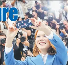  ??  ?? Cast member Lea Seydoux takes a selfie with a mobile phone as she poses during a photocall for the film ‘Saint Laurent’ at the 67th Cannes Film Festival. — Reuters file photo