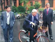  ?? LI XIAOKUN / CHINA DAILY ?? Tatsuyoshi Takashima, the senior corporate adviser at Dentsu Inc, takes a ride on a shared bicycle in Shanghai between talks by media profession­als on Monday.