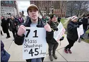  ?? PAUL SANCYA / AP ?? Austin Hunt holds a sign with current and former Michigan State University students during a rally at the capitol in Lansing, Mich. on Wednesday.