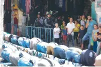  ?? (Marc Israel Sellem/The Jerusalem Post) ?? MUSLIMS PRAY in front of the Chain Gate (Bab al-Silsala) entrance to the Temple Mount yesterday as Border Police officers and Muslim Quarter residents look on.