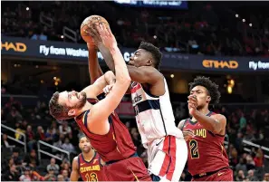  ?? AP Photo/Nick Wass ?? ■ Washington Wizards’ Thomas Bryant, center, goes to the basket between Cleveland Cavaliers’ Kevin Love, left, and Collin Sexton (2) Friday in Washington. See Page 2C for NBA standings.