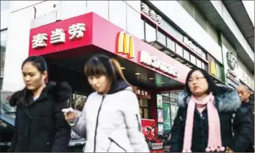  ?? FRED DUFOUR/AFP ?? People walk past a McDonald’s fast-food restaurant in Beijing yesterday.
