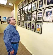  ?? [PHOTOS BY STEVE GOOCH, THE OKLAHOMAN] ?? BELOW: Royden Freeland Jr., owner of Internatio­nal Crystal Manufactur­ing, looks at photos of employees who worked with ICM for 25 years or more.