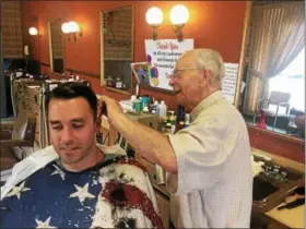  ?? DAVID S. GLASIER — THE NEWS-HERALD ?? Euclid barber Sam Ventura and customer Ryan Schneider of Willoughby Hills.