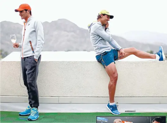  ?? Photos: GETTY IMAGES ?? Roger Federer holds a glass of champagne as he talks to the media while Rafael Nadal talks on the phone at the Indian Wells Tennis Garden in California. Right: Last week’s super-fight was a clear case of Good (Many Pacquiao) versus Evil (Floyd...