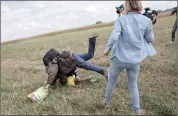  ??  ?? HEARTLESS: A refugee carrying a child is sent sprawling after being tripped by TV camerawoma­n Petra Laszlo. Laszlo, who worked for a private TV channel in Hungary, was fired after videos of her kicking and tripping refugees fleeing police spread on...