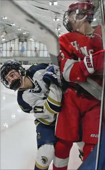  ?? CHRIS CHRISTO — BOSTON HERALD ?? Hingham’s Travis Rugg is checked into the boards by St. Mary’s Jaiden Driscoll during a Jan. 16 boys hockey clash in Lynn. Hingham is enjoying another strong season.