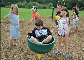  ??  ?? Isabella Ferriola, left, and Milena Franklin watch as Nicholas Lewis tries out the new play ground equipment at Glen Acres Elementary School.