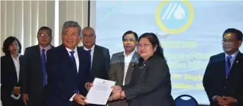  ??  ?? Dr Rundi (second row, second right) witnesses the handing over of chairmansh­ip between Dato Ir Alice (right) and Nelson (second right) at Laku Management Sdn. Bhd. office here yesterday.