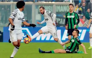  ?? AFP ?? Juventus’ Gonzalo Higuain (centre) fights for the ball with Sassuolo’s defender Francesco Acerbi during their Italian Serie A match. —