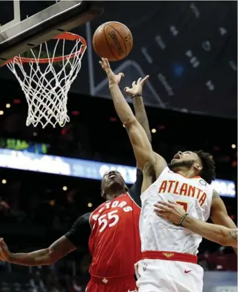  ?? DAVID GOLDMAN/THE ASSOCIATED PRESS ?? Atlanta’s Tyler Dorsey and Raptor Delon Wright battle under the rim in Wednesday night’s action.