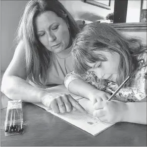  ?? ROSIE MULLALEY/THE TELEGRAM ?? Shilo Stagg of Paradise, N.L., teaches her eight-year-old daughter, Lexie, cursive writing regularly at home, since it’s not part of the school curriculum and, therefore, not a requiremen­t in class.