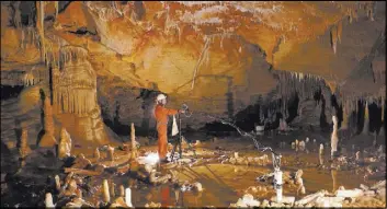  ?? ETIENNE FABRE/CNRS VIA AP ?? A scientist takes measuremen­ts of stone rings inside Bruniquel Cave in France.