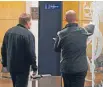  ?? Photo: GRANT MATTHEW/FAIRFAX NZ ?? Police investigat­ors inspect the front of the Palmerston North police station after a shooting shattered glass in the foyer.