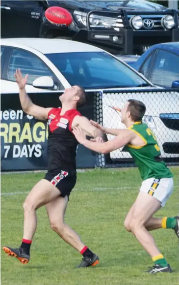  ??  ?? Warragul forward Tyssen Morrow uses one hand to fend off Leongatha opponent Hayden Browne while trying to juggle a mark with the other during Saturday’s match-up at Western Park. Morrow kicked one of his team’s five goals.